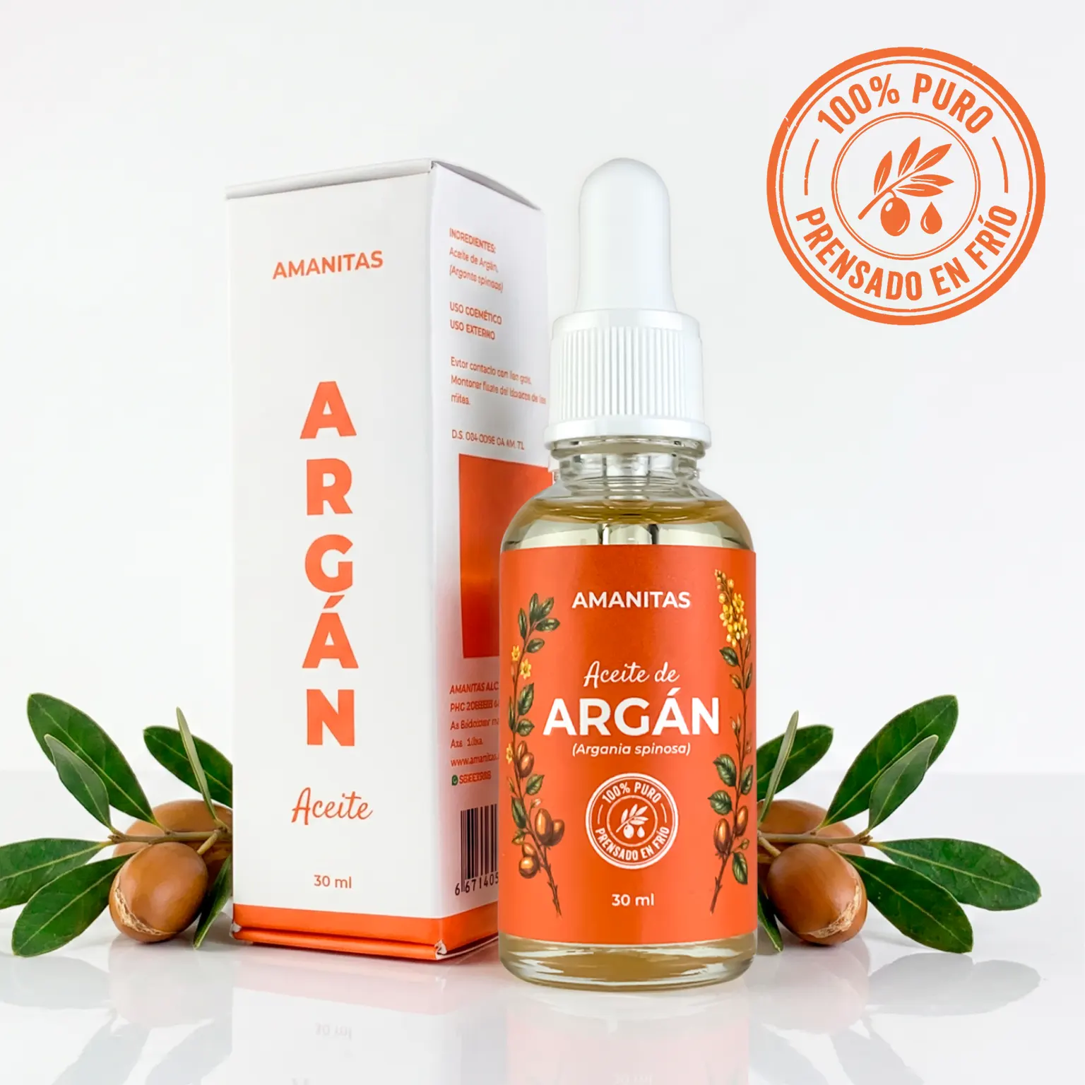 Presentación premium del Aceite de Argán 100% puro de la marca Amanitas. Frasco de vidrio de 30 ml con gotero y su caja minimalista, acompañados de semillas y hojas botánicas de argán (Argania spinosa). Producto extraído por prensado en frío.