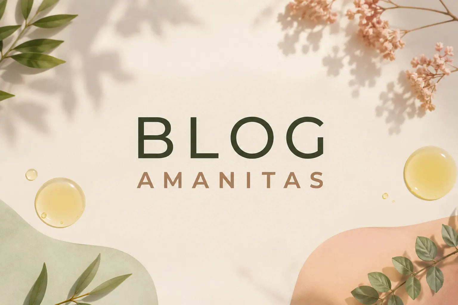 Banner de cabecera horizontal para el Blog Amanitas con texto "BLOG" (verde) y "AMANITAS" (beige). Fondo blanco con sombras suaves de hojas y flores blancas. Incluye un cuenco de aceite dorado, un gotero y formas de acuarela verde claro y rosado.